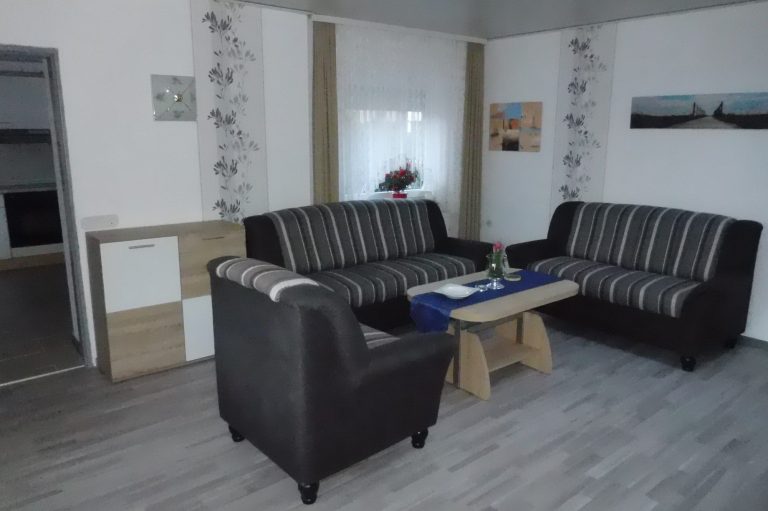 Couch und Sessel in der Ferienwohnung Leer in Ostfriesland Tisch und Fenster