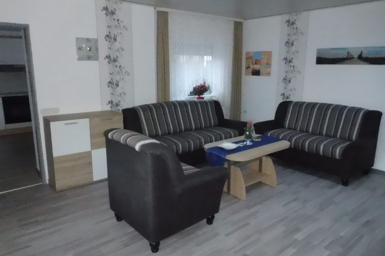 Couch und Sessel in der Ferienwohnung Leer in Ostfriesland Tisch und Fenster
